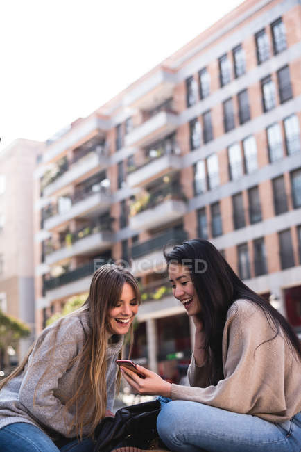 Друзья смотрят на свой смартфон на улицах Мадрида — стоковое фото