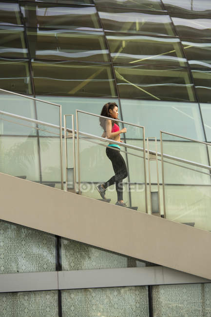 A young asian woman is jogging in the marina bay area of Singapore — Stock Photo