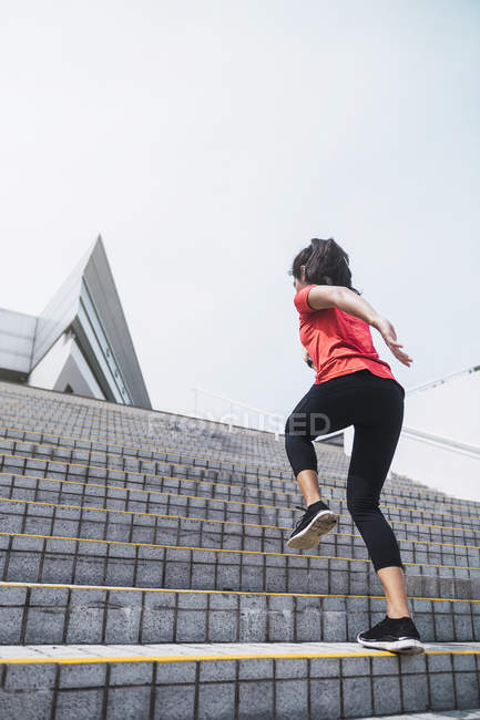 Joven asiático deportivo mujer corriendo hasta arriba en escaleras - foto de stock