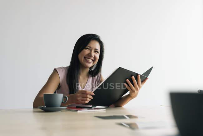 Junge asiatische erfolgreiche Geschäftsfrau mit Notizblock im modernen Büro — Stockfoto