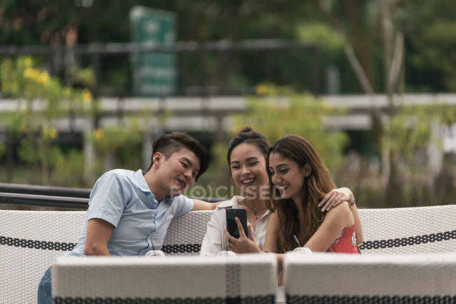 Groupe d'amis dans un restaurant regardant le téléphone — Photo de stock
