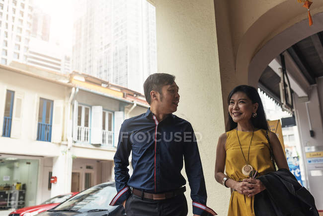 Счастливая молодая азиатская пара, идущая по улице — стоковое фото