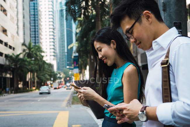 Jeune couple d'affaires adulte utilisant des appareils numériques — Photo de stock