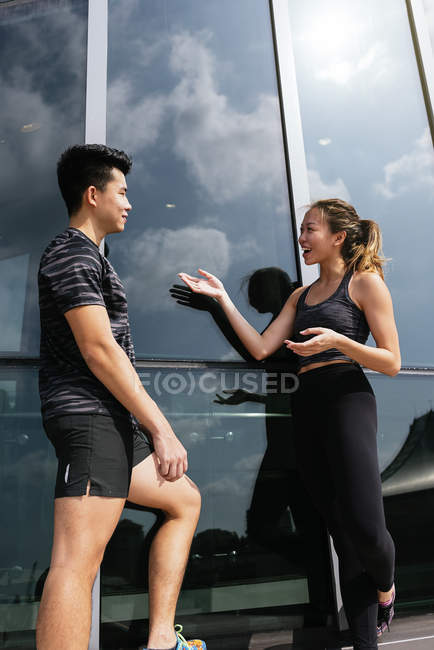 Happy asian sporty couple talking to each other — Stock Photo
