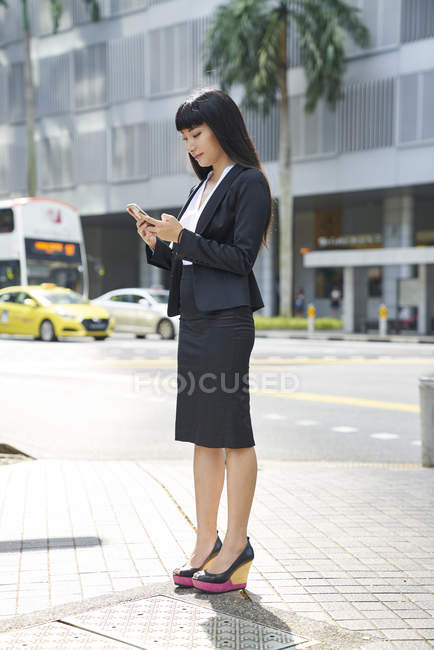 Asiatico affari donna controllo telefono — Foto stock