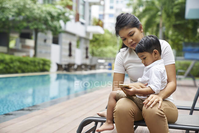 Madre e figlio legame a bordo piscina — Foto stock
