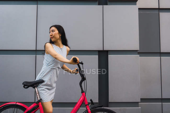 Jovem mulher asiática andando com bicicleta — Fotografia de Stock
