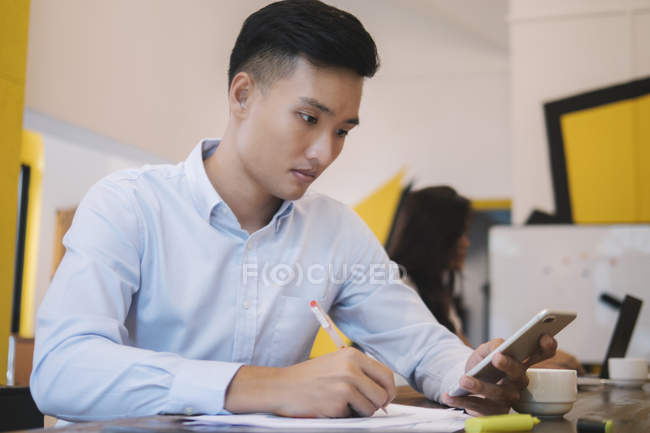 Jovem asiático homem trabalhando no criativo moderno escritório — Fotografia de Stock
