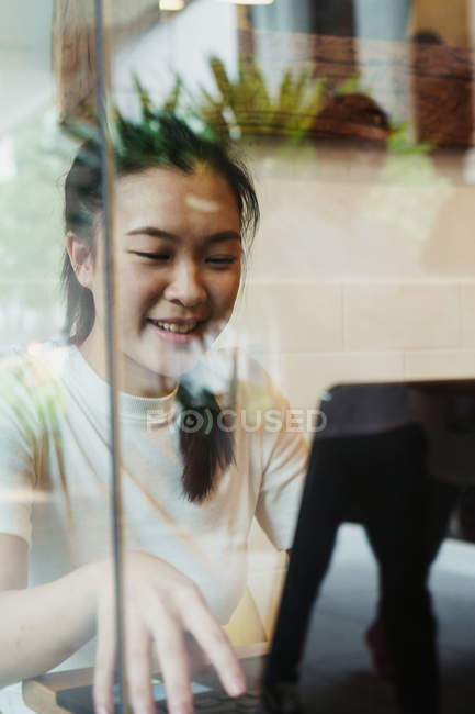 Jeune attrayant asiatique femme en utilisant ordinateur portable — Photo de stock