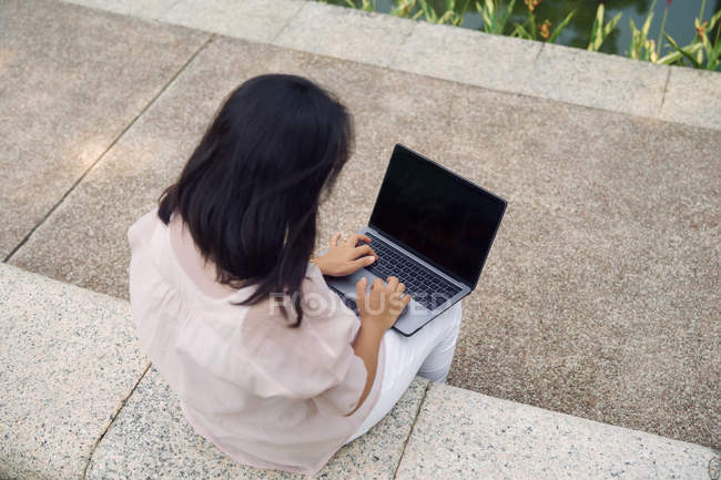 Erwachsene Frau benutzt Laptop im Park — Stockfoto