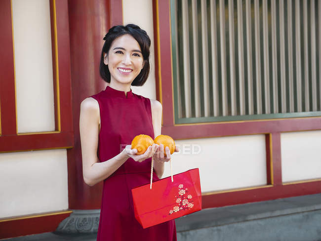 Chinês mulher segurando laranjas — Fotografia de Stock