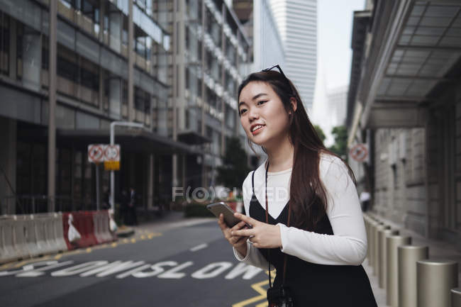 Chinese long hair woman looking away against road — Stock Photo