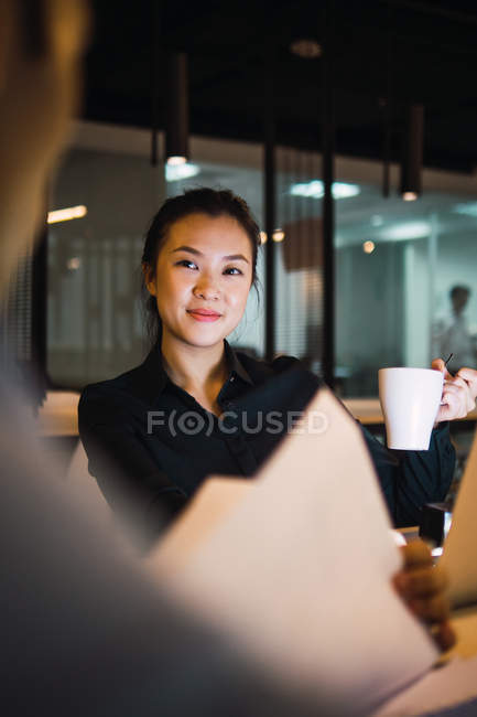 Jeune femme d'affaires adulte avec café au bureau moderne — Photo de stock