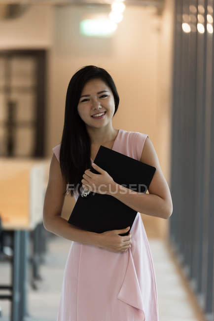 Jeune asiatique succès femme d'affaires avec bloc-notes dans le bureau moderne — Photo de stock