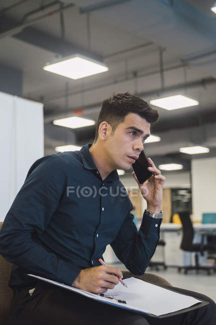 Jeune homme d'affaires asiatique travaillant dans un bureau moderne — Photo de stock