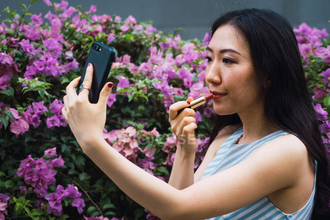 Jeune femme asiatique prendre selfie et l'application de rouge à lèvres — Photo de stock