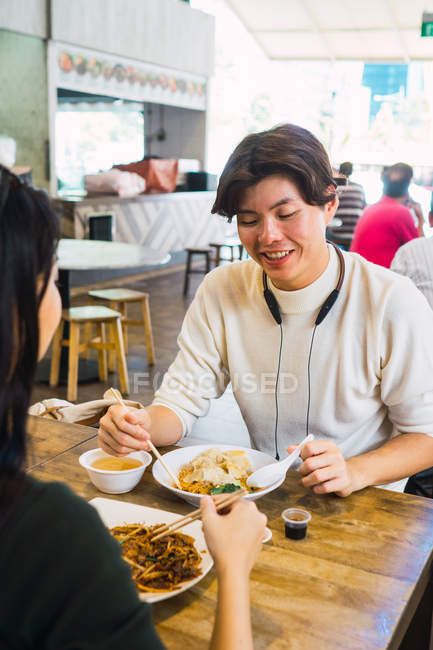 Jovem asiático casal comer comida no café — Fotografia de Stock