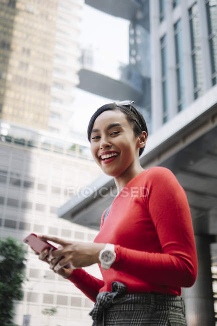 Jeune asiatique attrayant femme en utilisant smartphone — Photo de stock
