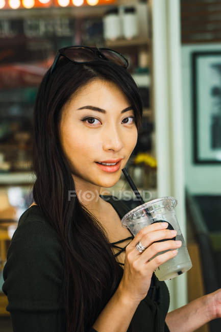 Junge asiatische Frau trinkt Getränk — Stockfoto