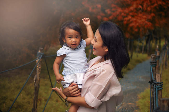 Bonito asiático mãe e filha abraçando no parque — Fotografia de Stock