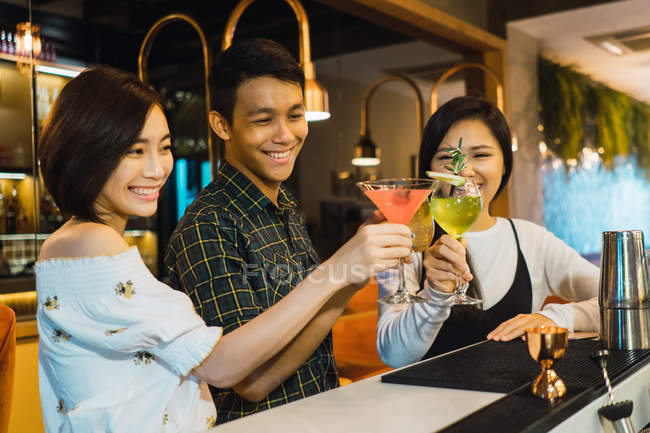 Молодые азиатские друзья аплодируют в уютном баре — стоковое фото