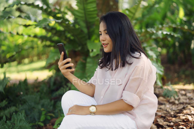 Felice donna asiatica prendendo selfie nel parco — Foto stock