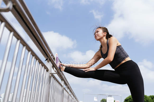 Chinese woman stretching outdoors — Stock Photo