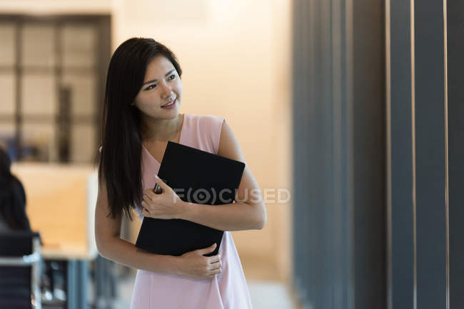 Молодая азиатская успешная предпринимательница с блокнотом в современном офисе — стоковое фото