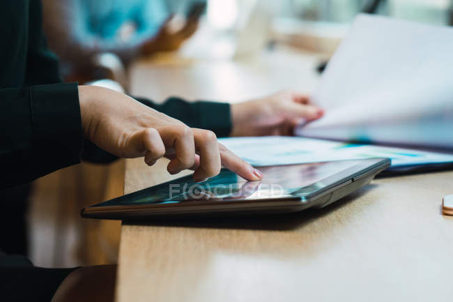 Image recadrée de femme d'affaires réussie en utilisant une tablette numérique dans le bureau moderne — Photo de stock