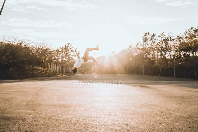 Jovem ásia homem fazendo parkour no por do sol — Fotografia de Stock