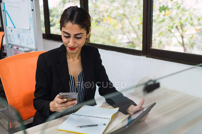 Joven asiático negocios mujer usando smartphone en moderno oficina - foto de stock