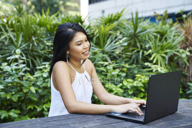 Jovem mulher bonita em seu laptop ao ar livre — Fotografia de Stock