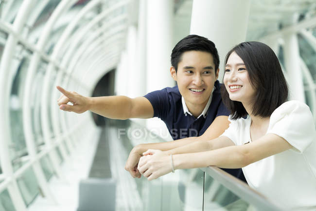 Jovem asiático casal apontando em algo — Fotografia de Stock