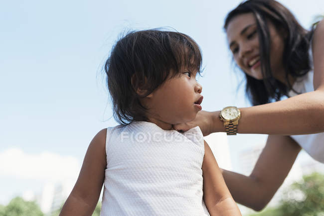 Casual joven madre con asiático hija - foto de stock
