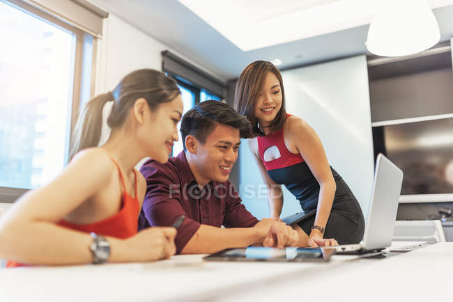 Jeunes gens asiatiques attrayants travaillant dans un bureau moderne — Photo de stock