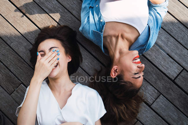 Junge schöne asiatische Frauen zusammen auf dem Boden liegend — Stockfoto
