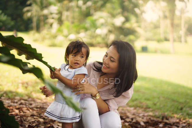 Lindo asiático madre y hija jugando en otoño parque - foto de stock