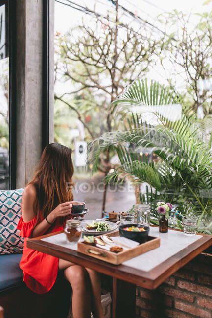 Азиатка пьет кофе в ресторане — стоковое фото