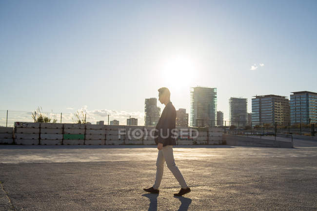 Vista lateral de jovem asiático homem andando ao ar livre — Fotografia de Stock