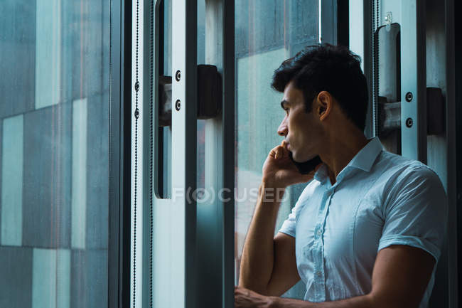 Jeune homme d'affaires adulte utilisant un smartphone au bureau moderne — Photo de stock