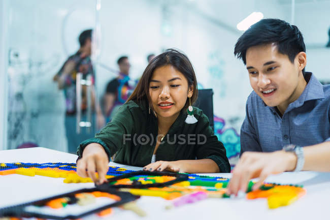 Junge asiatische Geschäftsleute spielen mit Spielzeug im modernen Büro — Stockfoto