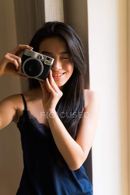 Mujer joven china posando con una cámara vintage - foto de stock
