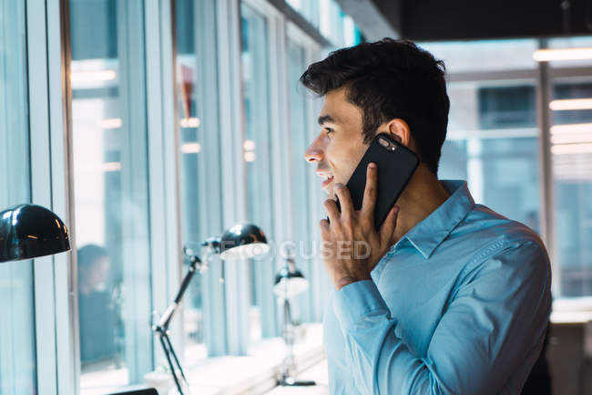Young adult business man using phone at office — Stock Photo