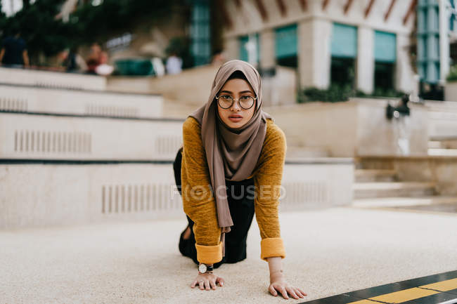 Junge asiatische muslimische Frau im Hijab posiert auf dem Fußboden — Stockfoto