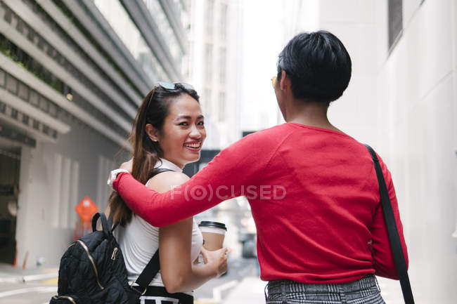 Young asian female friends hugging and walking — Stock Photo