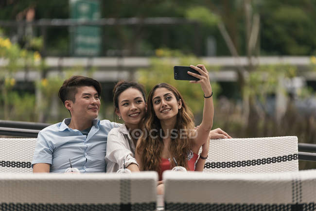 Gruppo di amici in un ristorante a farsi selfie — Foto stock