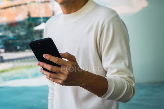 Cropped image of asian man using smartphone, closeup — Stock Photo