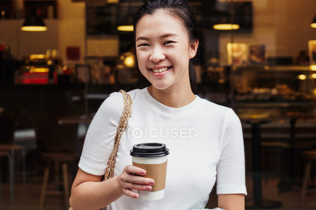 Young attractive asian woman with coffee cup — Stock Photo
