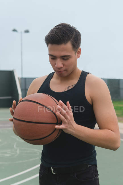 Junger Mann hält Basketball in der Hand — Stockfoto