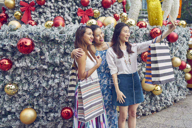 Young attractive asian women at christmas shopping taking selfie — Stock Photo